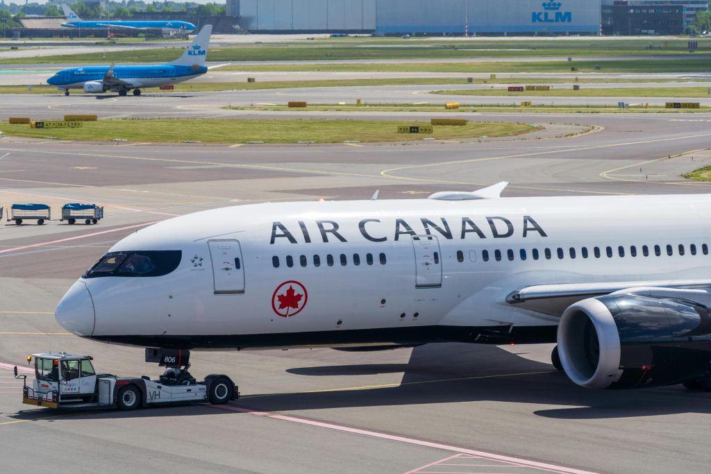 Air Canada Boeing 787 Dreamliner on the airport tarmac during a sunny day.
