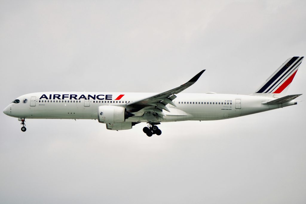 Side view of Air France Airbus A350-900 aircraft flying against a cloudy sky.
